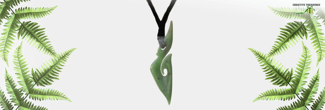 Close-up of a beautiful greenstone necklace, featuring a finely carved pendant made from pounamu, surrounded by fern leaves in a minimalist design.